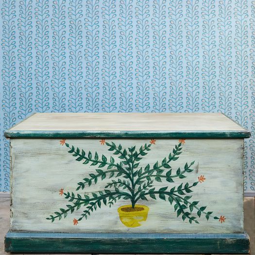 A hand-painted pine blanket box with botanical motif and hinged lid
