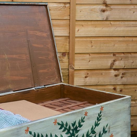 A hand-painted pine blanket box with botanical motif and hinged lid