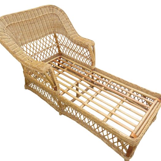 A vintage wicker day bed or chaise longue,with cream upholstered mattress and cushions