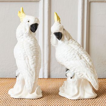 A pair of hand-painted Crown Staffordshire bone china cockatoo figurines with yellow crests, designed and modelled by J.T. Jones
