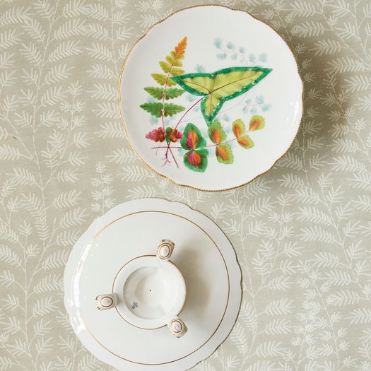 A pair of 19th century porcelain comports with a decorative leaf pattern on a gold three- footed stand.