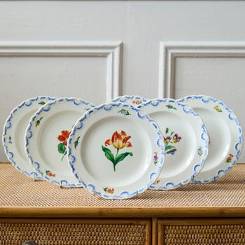 A set of six  early 20th century Meissen hand painted porcelain plates, each with a flower motif and scalloped, wavy rim with a blue border design.