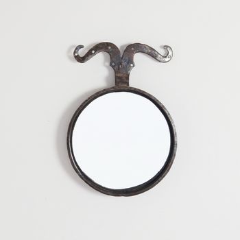 A Circular Iron Mirror with Moustache Detail